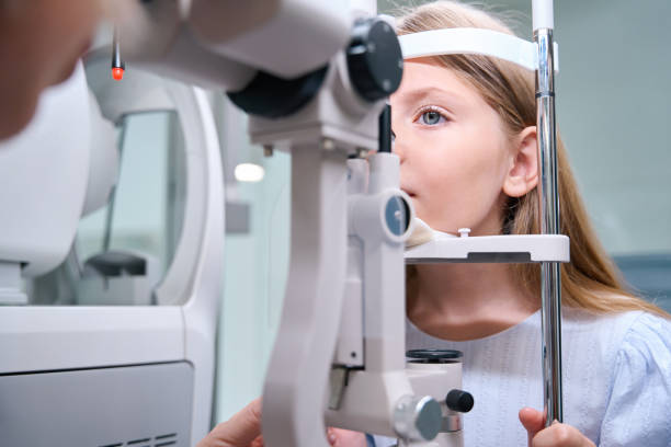 istock Focused little girl undergoing eye exam on ophthalmic device 1669935871