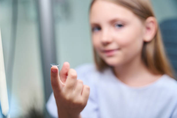 Little girl showing her corrective lenses in front of camera stock photo