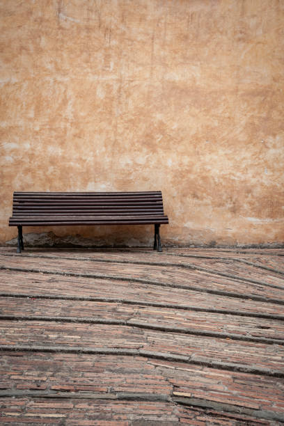 istock Empty bench against a wall in an Italian village 1669948664