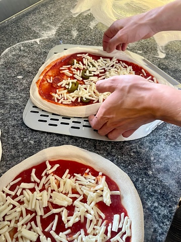Pizzaiolo puts pizzas on a shovel