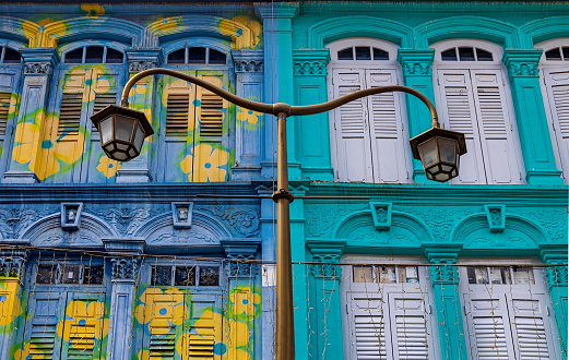 Detail of colorful Chinatown buildings in Singapore. The architectural style of these buildings was influenced by Chinese traditions with  European classical elements and Malay influences such as columns and louvered shutters.