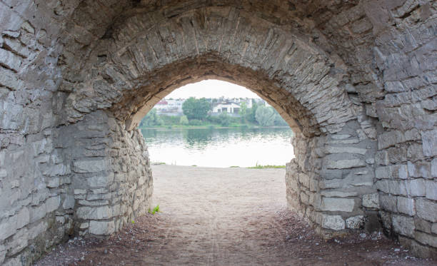 An old stone arch leading to the river. Old brick arch.