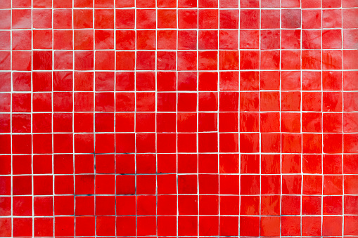 Various shades of red mosaic ceramic tiles on wall texture background. Classic square mosaic tiles