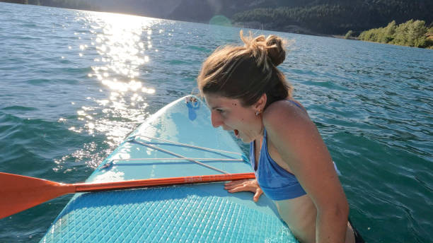 istock Young woman enjoys SUP board on lake 1670065483