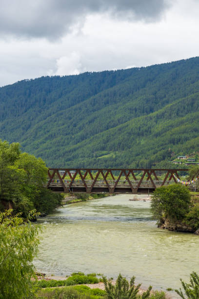 istock View of a river flowing in a valley surrounded by greenery with clouds over mountains in Bhutan. 1670077284