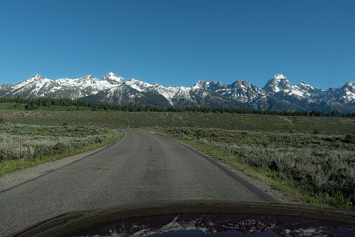 Highway approaching the Teton range in Wyoming of western USA in North America.