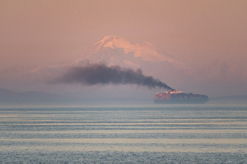 Cargo Ship in the distance with exhaust fumes and Mt. Baker in the distance.