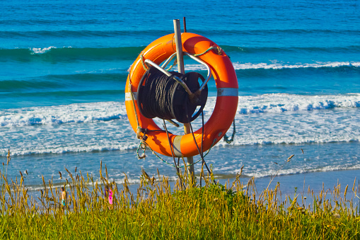 Orange buoy floating on sea surface waves. Human life safety concept.