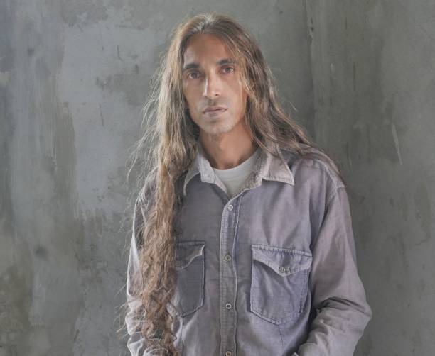 istock Long haired man wearing gray shirt looking at camera 1670121485