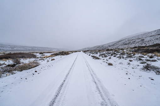 Road to Jeinimeni National Reserve covered by snow on a cloudy day in the chilean Patagonia