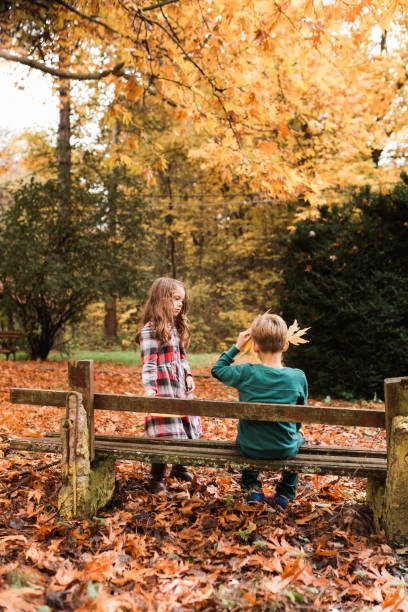 istock Children having fun playing with dry maple leafs in autumn park 1670207268