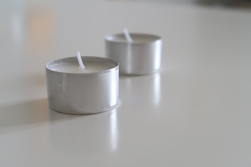 Tealights on a White Table, Minimalistic White Nordic Home Decor, warm tone candlelights, blurry background, focused picture