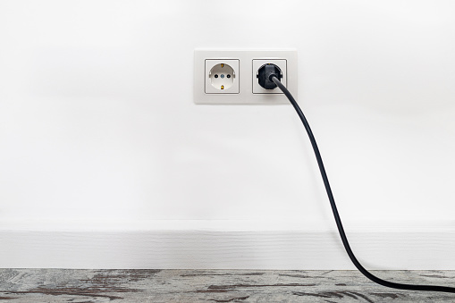 Power plug in on white wall