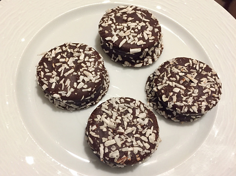 Chocolate covered cookies with coconut powder in a plate
