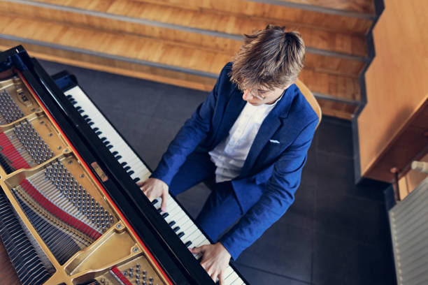 istock Teenage boy is practicing playing grand piano 1670364363