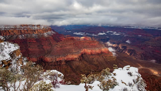 Panning Timelapse of fog moving over snow covered Grand Canyon panorama view.