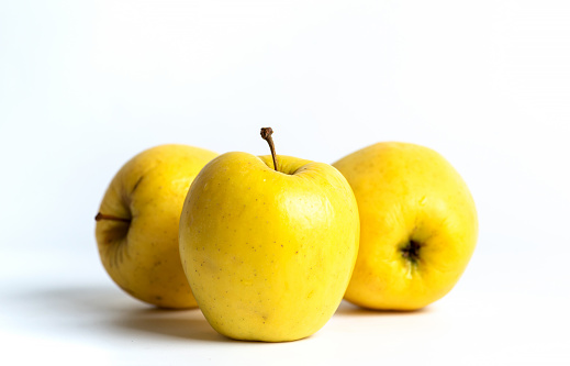 Fresh, ripe, three yellow apples on a white background
