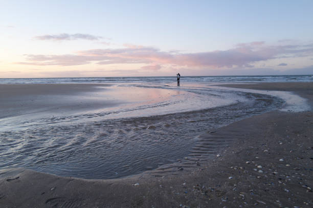 istock A couple on the beach taking in the beautiful sunset. 1670598454