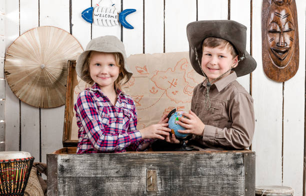 istock little boy and girl study globe in big chest 1670694531