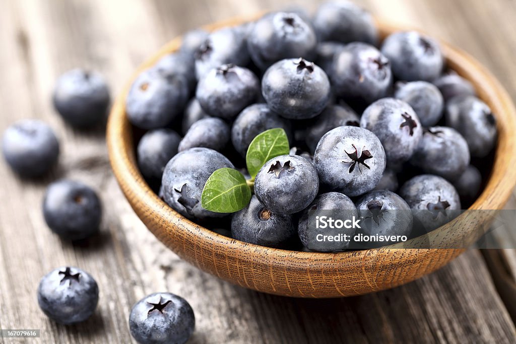 Blueberry in a wooden plate Ripe blueberry in a wooden plate Berry Fruit Stock Photo