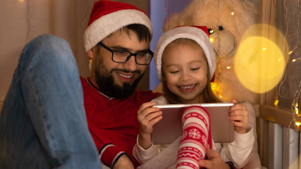 la familia feliz usa la tableta y ríe. año nuevo vacaciones de navidad - child 4 5 years laughing little girls fotografías e imágenes de stock