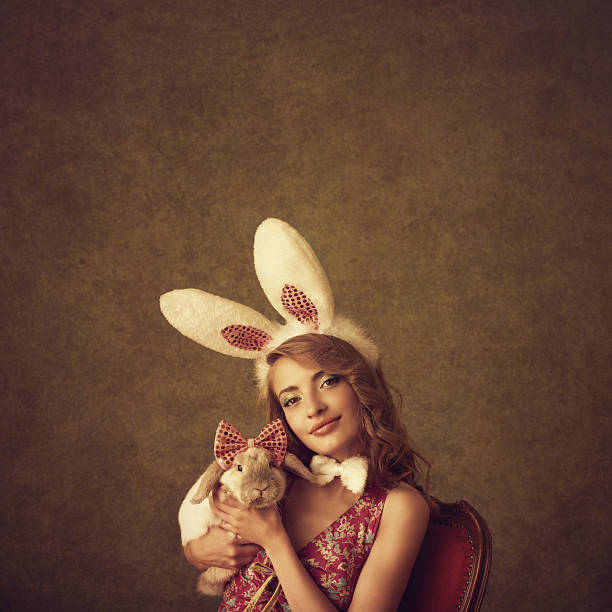 playboy-bunny holding a rabbit - bunny girl stock-fotos und bilder