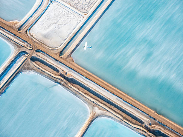 istock Abstract aerial view of salt mining and small plane 1670863064