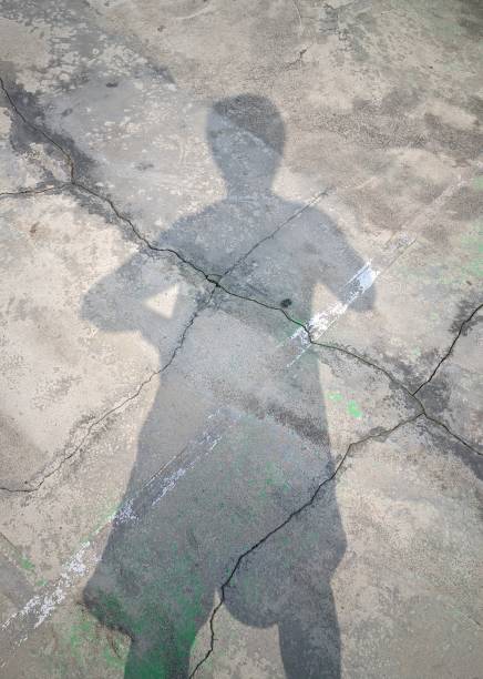 istock Shadow of Young Person on Cement Floor Surface 1670890271