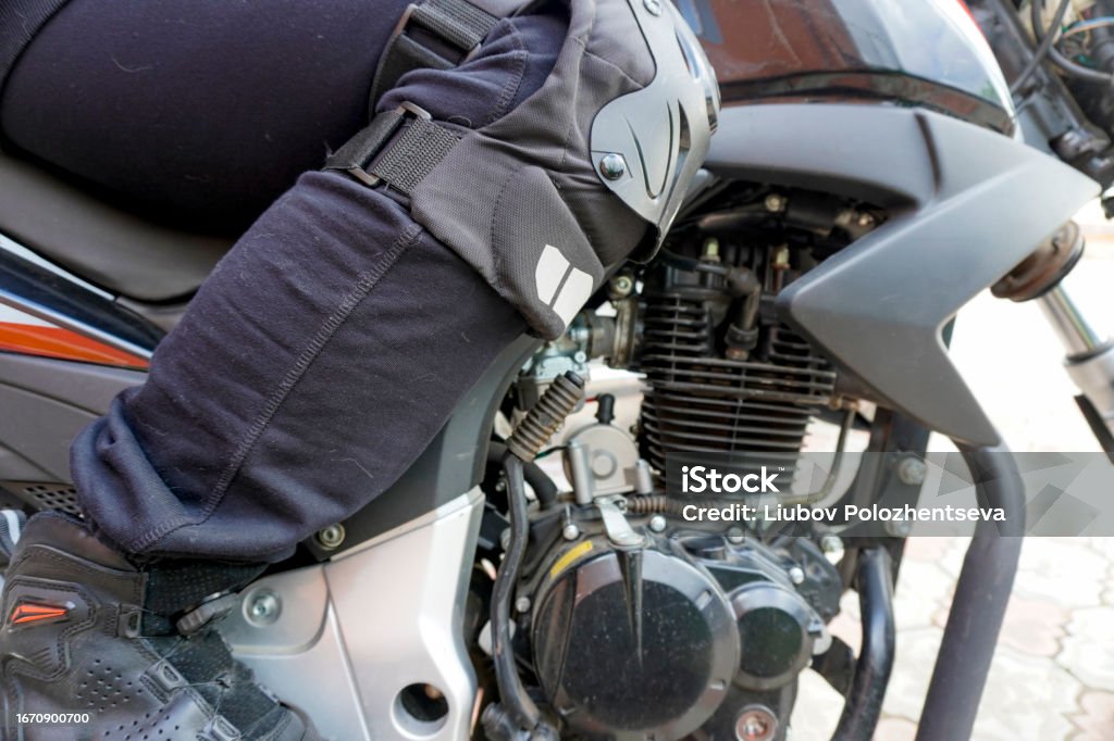 woman motorcyclist in a motorcycle boots on a motorcycle close-up woman motorcyclist in a  motorcycle boots on a motorcycle close-up Adult Stock Photo