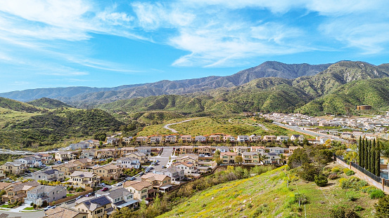 The urban area of Corona, California from the vantage of a drone.  The neighborhood nestle up against the poppy covered hillsides.