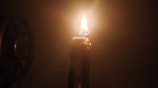 Light of candle in the dark. candle light that illuminates the dark. Single candle burning in the night