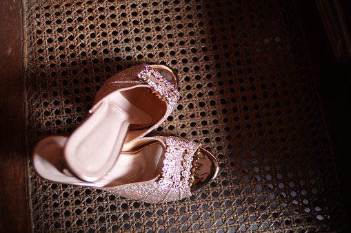The bride's cream-colored high heels on a bamboo table