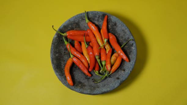istock some red chilies on a pestle with a yellow background 1671031913