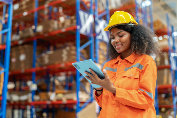 istock Senior warehouse manager in achieving productivity targets and maintaining seamless operations. African America holding a digital tablet to inspect and control stock inventory in the corrugated paper warehouse factory. 1671060596