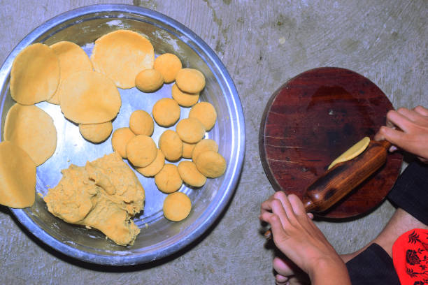 istock Girl hand rolling chapatis in a rural setting. Dough balls kept nearby. kitchen concept 1671082195