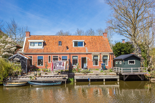 Boats at the jetty of little house in Onderdendam, Netherlands