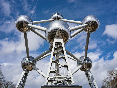 Brussels, Belgium - March 23, 2023: Atomium Structure in Brussels under blue summer sky, shot from below. The Atomium was built for the 1958. World's Fair. This building structure forms the shape of a unit cell of an iron crystal magnified 165 billion times, and stands 102 m tall. Architecture Detail with Hasselblad 102 MPixel X2D Camera. Brussels, Belgium, Europe.