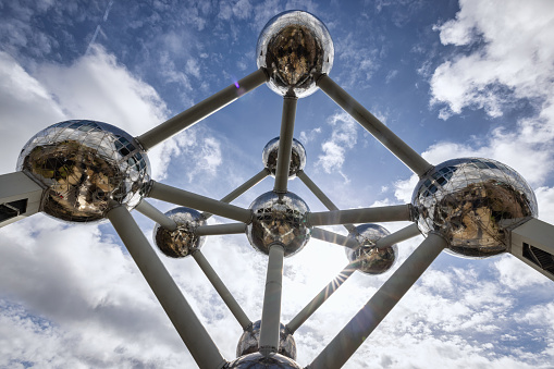 Brussels, Belgium - March 23, 2023: Brussels Atomium Structure Detail in Brussels under blue summer sky, shot from below. The Atomium was built for the 1958. World's Fair. This building structure forms the shape of a unit cell of an iron crystal magnified 165 billion times, and stands 102 m tall. Architecture Detail. Brussels, Belgium, Europe.