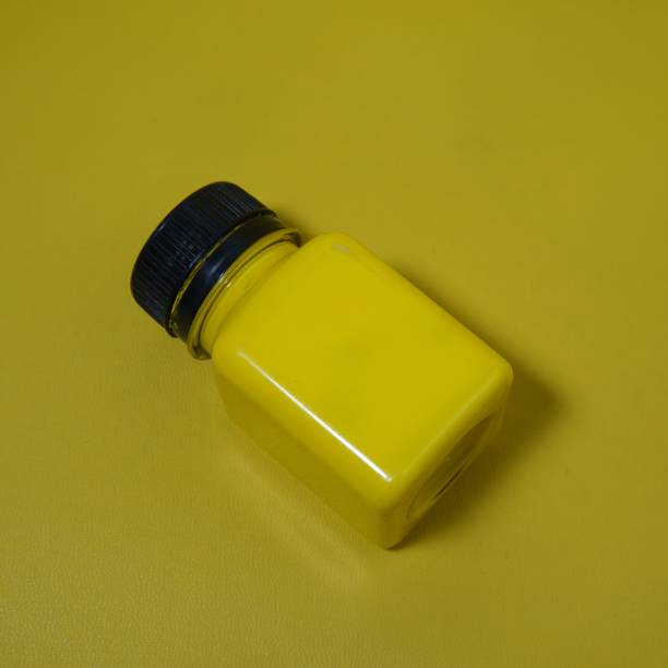 istock a bottle of yellow paint on a yellow base 1671161935