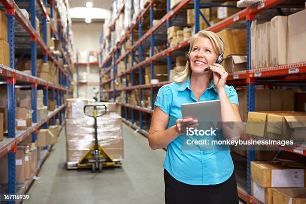 Woman Holding A Tablet With Headphones On In A Warehouse Stock Photo - Download Image Now