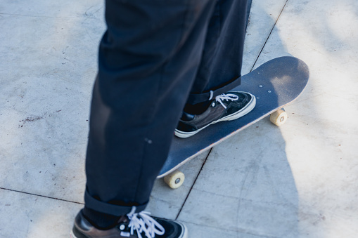 Close up of a skateboarder skating and holding his skateboard at the skatepark