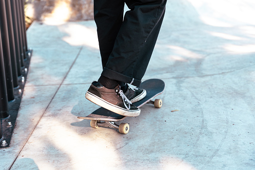 Close up of a skateboarder skating and holding his skateboard at the skatepark