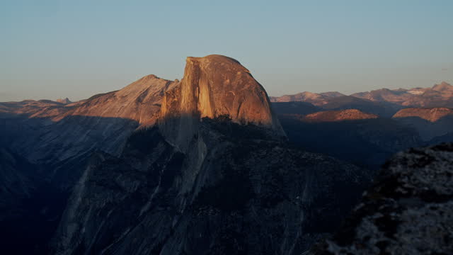 Pan reveal of half dome from Glacier Point on a golden afternoon