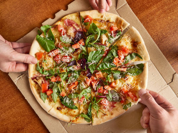 istock People enjoy pizza, each taking a piece. View from above. 1671190623