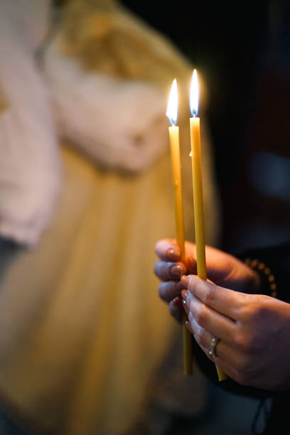 istock A woman holds lit candles in her hands during a religious service. 1671206637