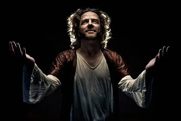 A stock photo of a biblical figure looking into the heavens with open arms against a dark background.http://www.bellaorastudios.com/banners/new01.jpg