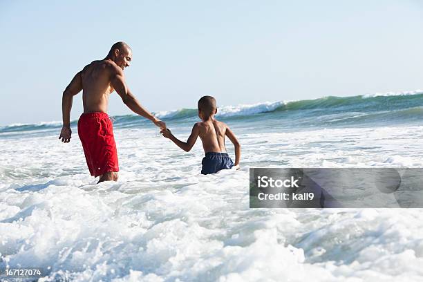 Photo libre de droit de Père Et Fils Jouant De Surf banque d'images et plus d'images libres de droit de Famille - Famille, Afro-américain, Plage