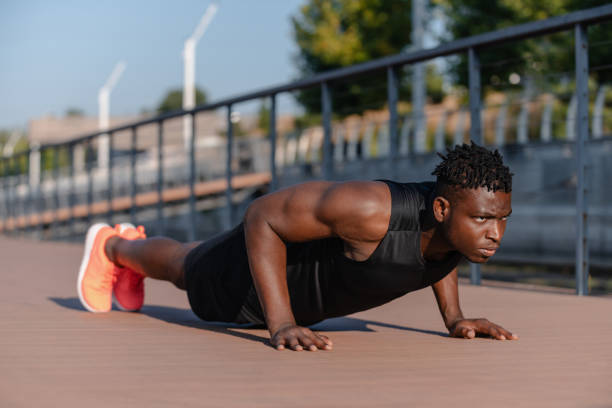 istock Confident African man in sportswear doing push-ups while exercising outdoors 1671321570