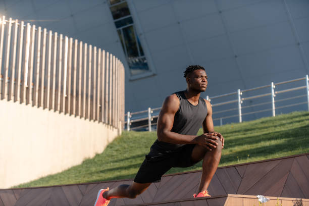 istock Confident young African man in sportswear doing stretching exercises while training outdoors 1671321573