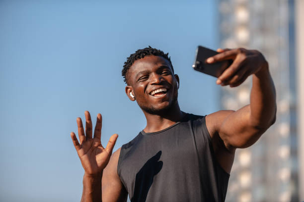 istock Happy young African athlete using smart phone and smiling while having video call outdoors 1671323696